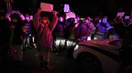 Protesters hold up blank papers and chant slogans