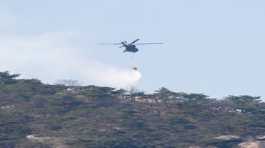helicopter tries to extinguish a forest fire